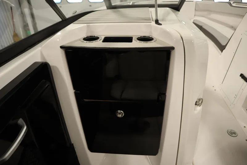 Slide: The Image of 2026 Yamaha Boats AR250 interior with sleek black storage compartment and cup holders. - 31