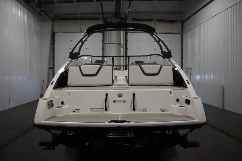 Slide: The Image of 2026 Yamaha Boats AR250 in a garage, rear view showcasing seating and design. - 5