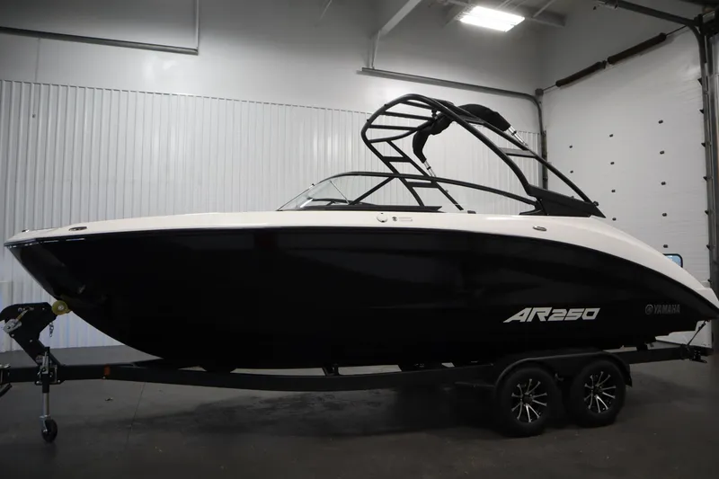 Slide: The Image of 2026 Yamaha AR250 boat in a showroom, sleek black and white design on a trailer. - 7