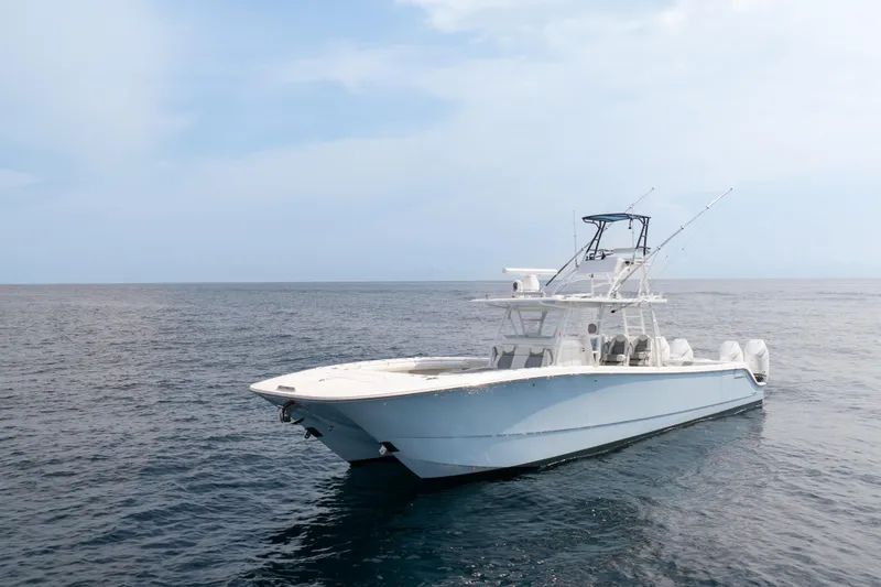 Slide: The Image of 2022 Invincible 46 Catamaran on open sea, showcasing sleek design and fishing equipment. - 1