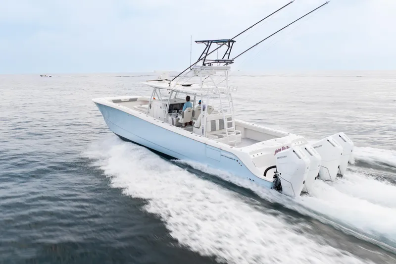 Slide: The Image of 2022 Invincible 46 Catamaran cruising on open water, showcasing powerful outboard engines. - 13