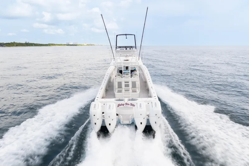 Slide: The Image of 2022 Invincible 46 Catamaran cruising on open water, rear view. - 14