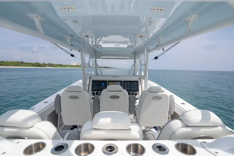 Slide: The Image of 2022 Invincible 46 Catamaran interior with ocean view, featuring modern seating and navigation controls. - 27