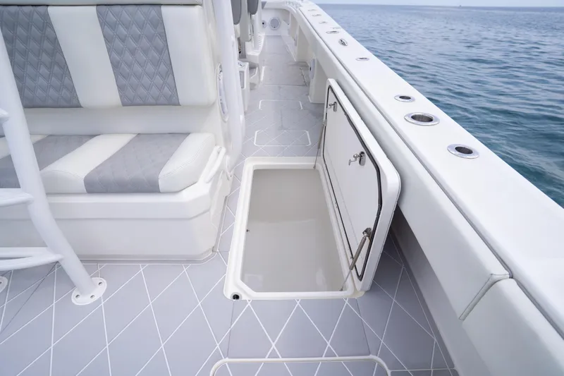 Slide: The Image of Invincible 46 Catamaran 2022 deck with open storage compartment and cushioned seating. - 38