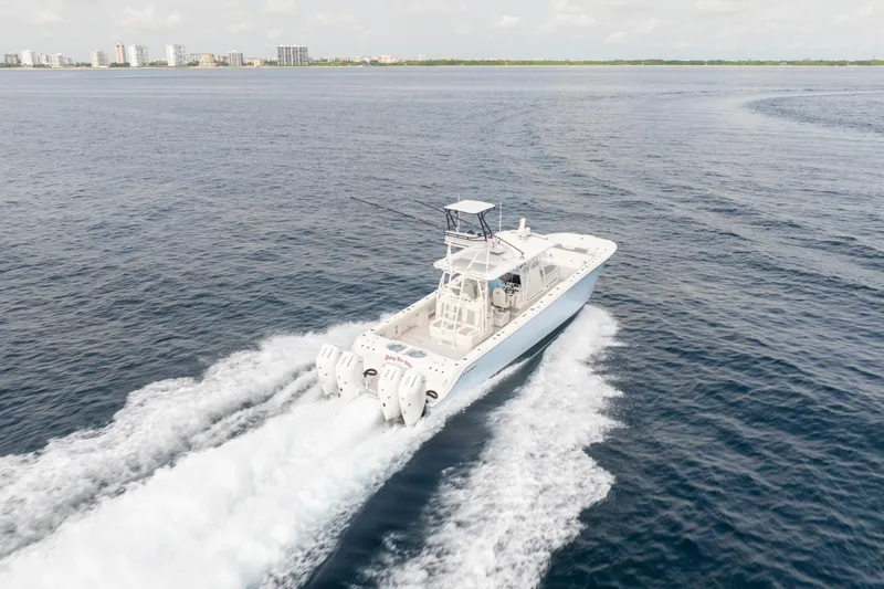 Slide: The Image of Invincible 46 Catamaran 2022 cruising on open water, city skyline in background. - 5