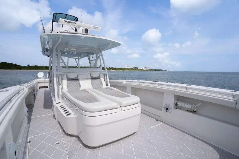 Slide: The Image of 2022 Invincible 46 Catamaran with spacious deck and seating, cruising on calm waters. - 53