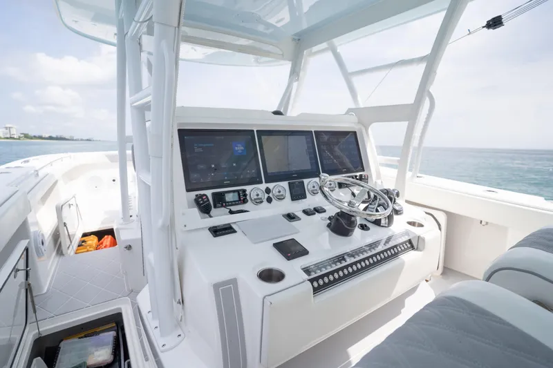 Slide: The Image of 2022 Invincible 46 Catamaran cockpit with advanced navigation systems and steering wheel. - 61