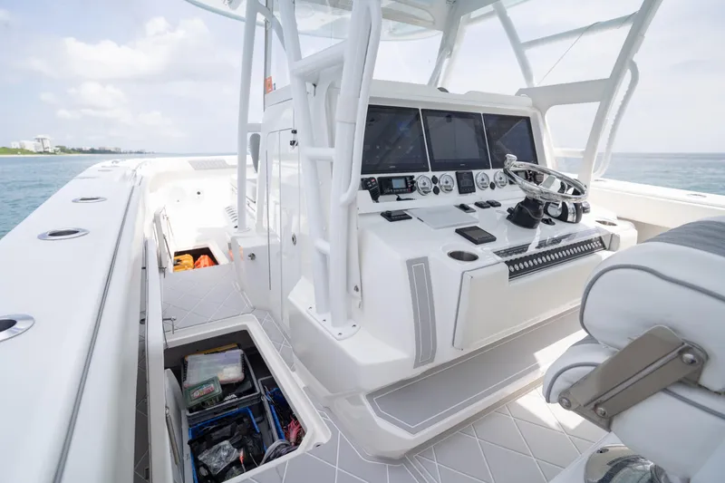 Slide: The Image of 2022 Invincible 46 Catamaran helm with advanced navigation systems and open storage compartment. - 63