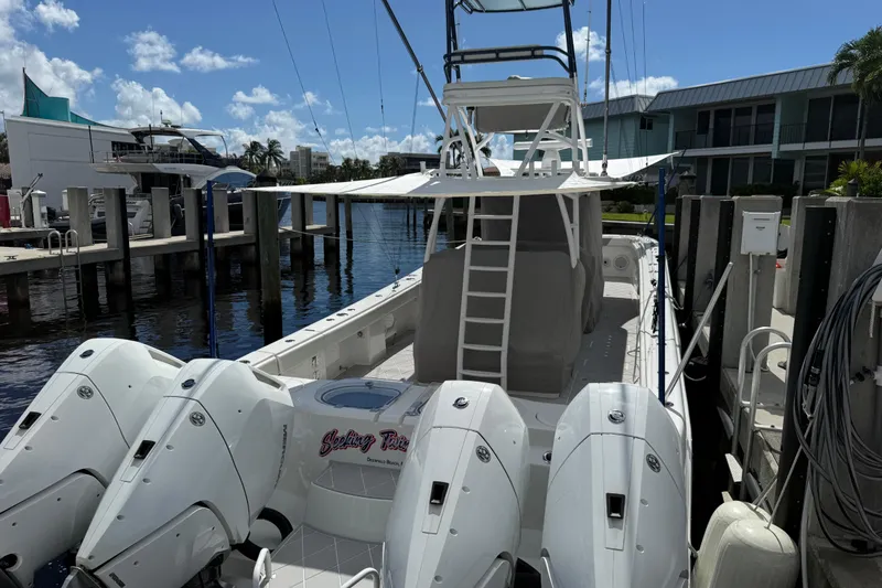 Slide: The Image of 2022 Invincible 46 Catamaran docked, featuring multiple outboard engines and a spacious deck. - 72