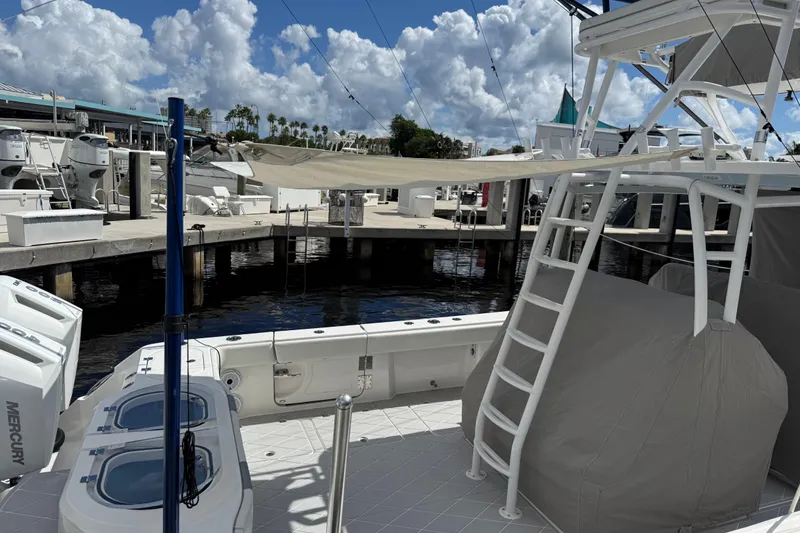 Slide: The Image of 2022 Invincible 46 Catamaran docked, showcasing deck and ladder under a cloudy sky. - 73