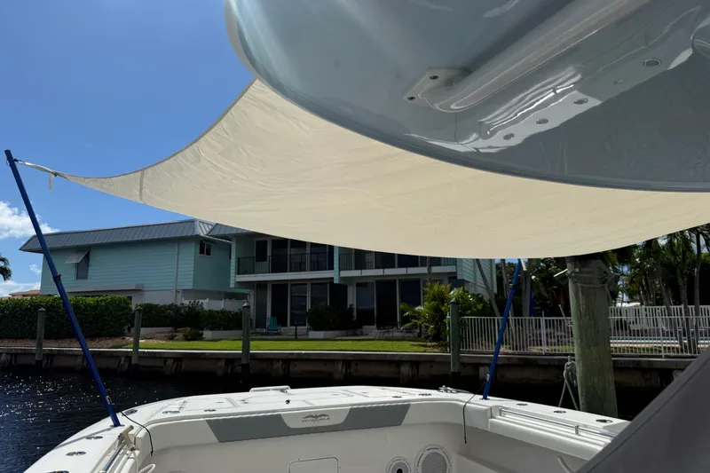 Slide: The Image of 2022 Invincible 46 Catamaran with sunshade, docked near waterfront home. - 77