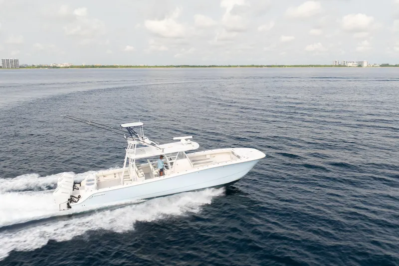 Slide: The Image of 2022 Invincible 46 Catamaran cruising on open water under a cloudy sky. - 9