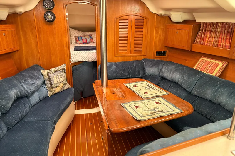 Slide: The Image of Cozy interior of 2002 Hunter 386 sailboat with blue seating and wooden accents. - 15