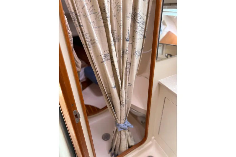 Slide: The Image of Shower area in 2002 Hunter 386 sailboat with nautical-themed curtain. - 22