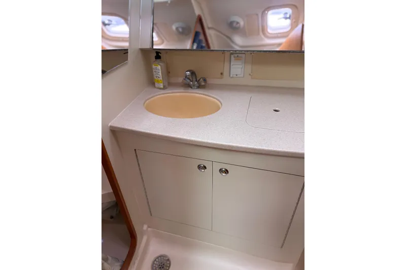 Slide: The Image of 2002 Hunter 386 yacht bathroom with sink, mirror, and storage cabinet. - 23