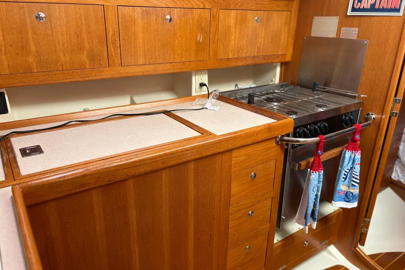 Slide: The Image of Wooden kitchen interior of 2002 Hunter 386 yacht with stove and storage cabinets. - 8