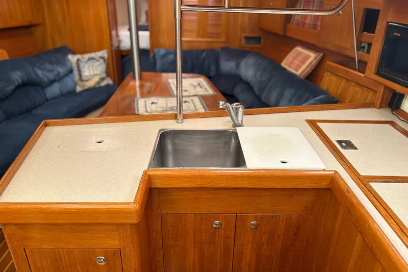 Slide: The Image of Interior of 2002 Hunter 386 yacht with wooden cabinetry and cozy seating area. - 9