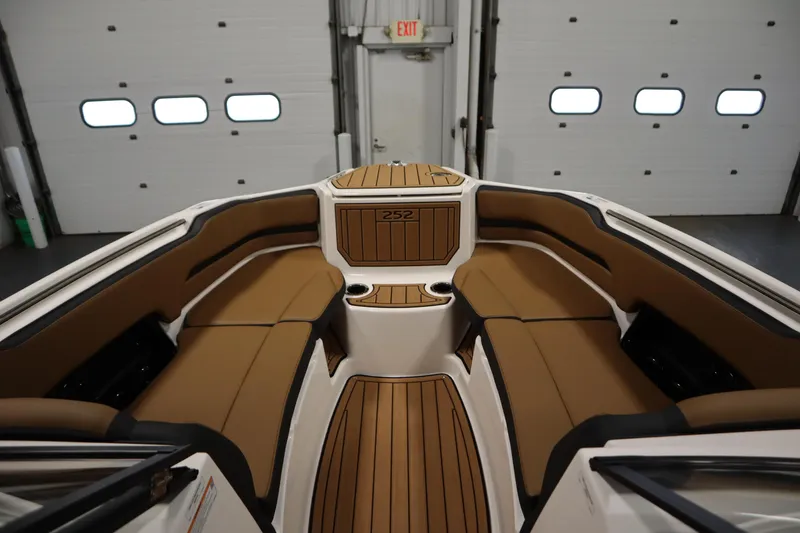 Slide: The Image of 2026 Yamaha Boats 252SD interior with tan seating and wood accents in a garage setting. - 10