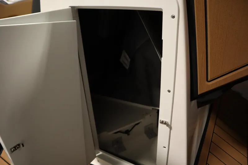 Slide: The Image of Open storage compartment on 2026 Yamaha Boats 252SD, featuring sleek design and wood accents. - 16