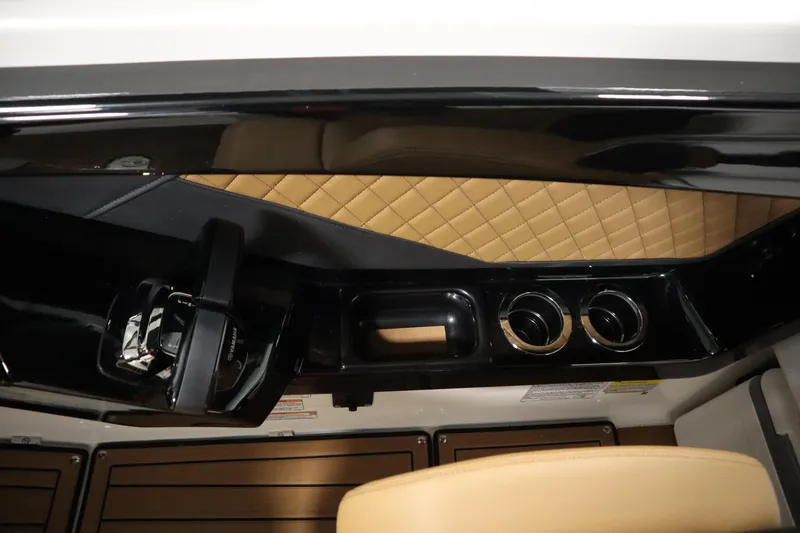 Slide: The Image of 2026 Yamaha Boats 252SD interior with tan quilted upholstery and sleek black dashboard. - 24