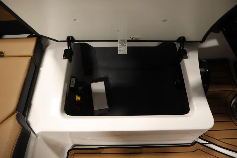 Slide: The Image of Open storage compartment in 2026 Yamaha Boats 252SD, featuring beige seating and sleek design. - 33