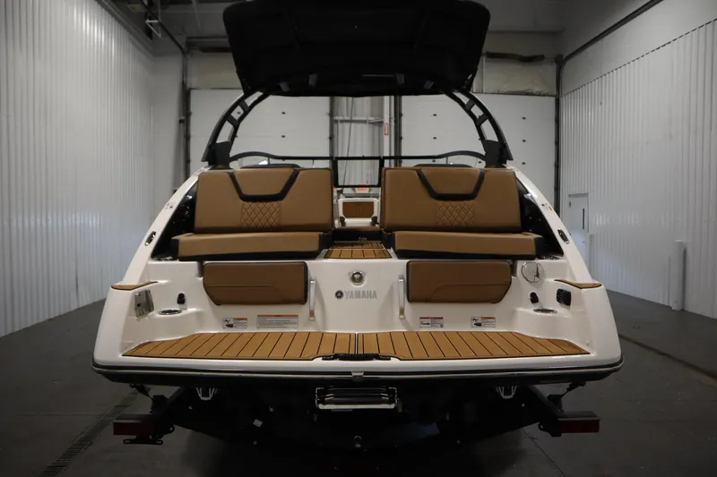 Slide: The Image of 2026 Yamaha Boats 252SD, rear view in a garage, showcasing seating and deck design. - 5