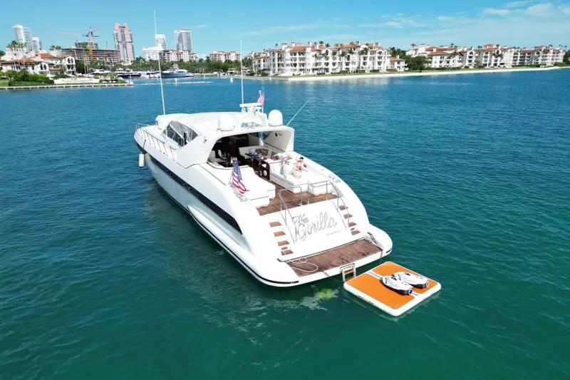 Slide: The Image of Luxury 1999 Mangusta 80 yacht on serene water with cityscape background. - 10