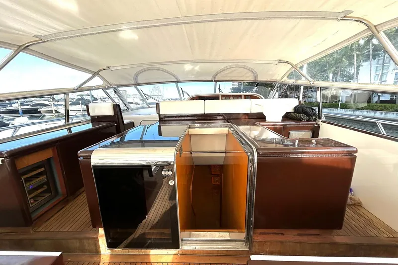 Slide: The Image of 1999 Mangusta 80 yacht with sleek design, docked near modern buildings, American flag visible. - 22