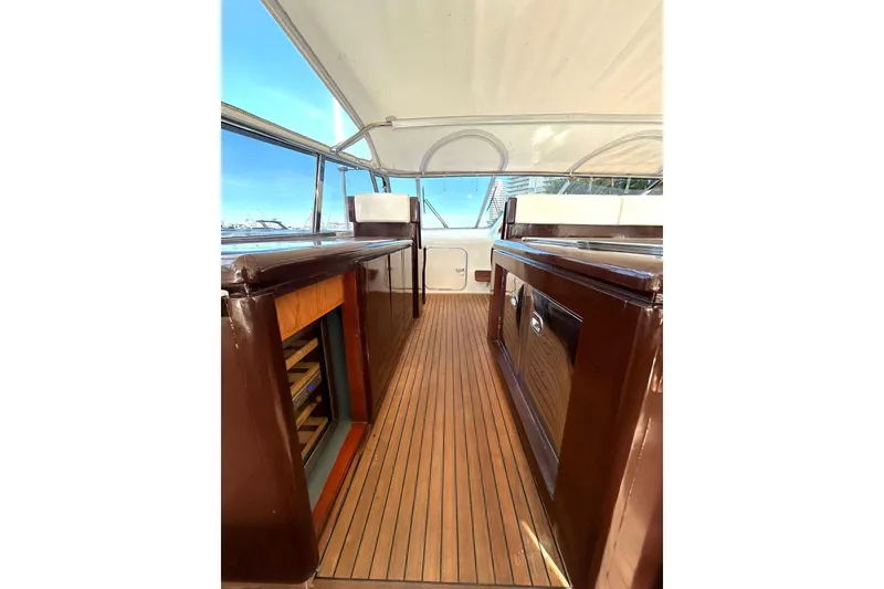 Slide: The Image of 1999 Mangusta 80 yacht deck with American flag, featuring sleek design and wooden flooring. - 26
