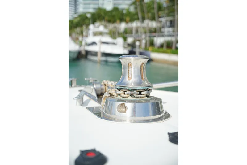 Slide: The Image of Close-up of a 1999 Mangusta 80 yacht's anchor winch with marina background. - 52