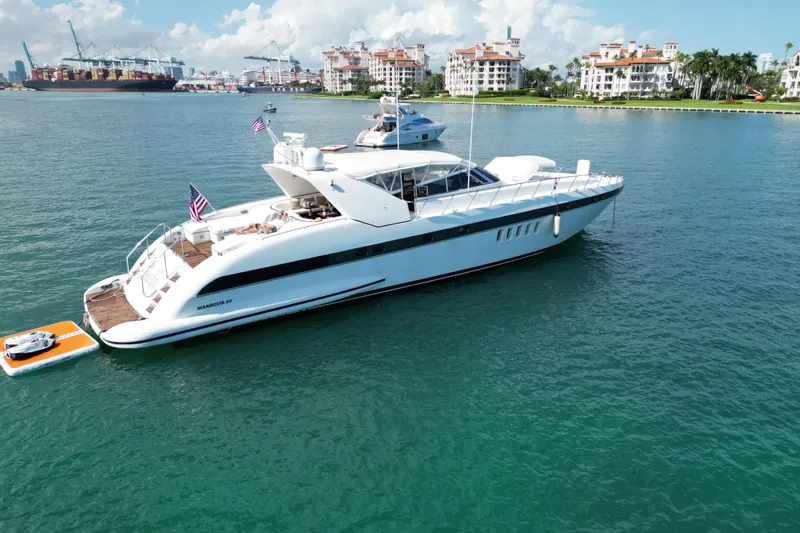 Slide: The Image of Luxurious 1999 Mangusta 80 yacht docked in scenic harbor with cityscape background. - 7