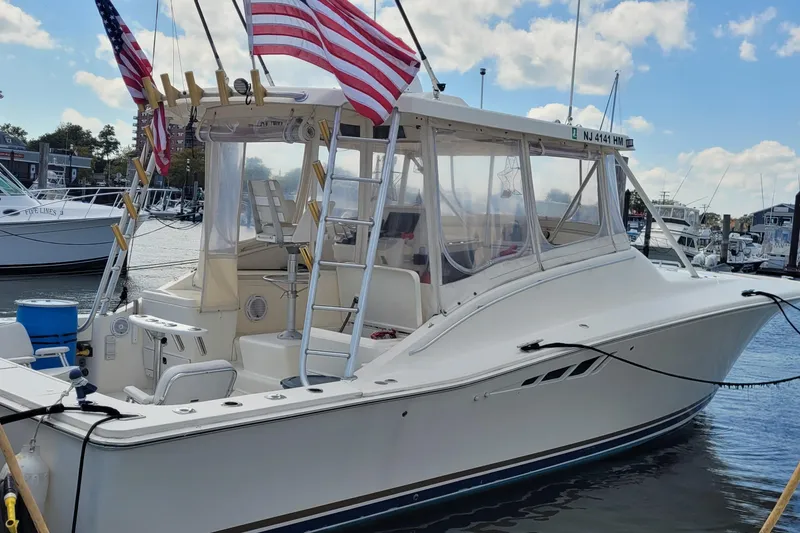 The Image of 1992 Luhrs 380 Open boat docked, featuring American flags and clear skies. - 0