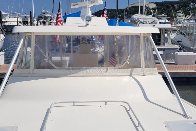 Slide: The Image of 1992 Luhrs 380 Open boat docked, featuring a covered helm and American flags. - 17