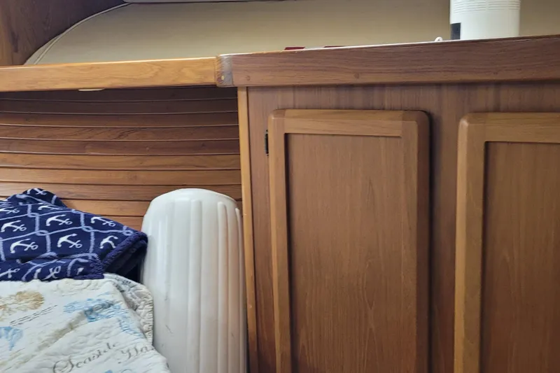 Slide: The Image of Interior of 1992 Luhrs 380 Open boat with wood paneling and nautical-themed bedding. - 26