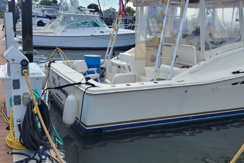 Slide: The Image of 1992 Luhrs 380 Open boat docked, featuring fishing gear and nautical equipment. - 3