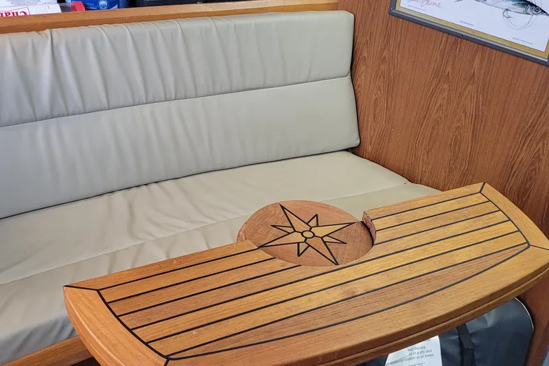 Slide: The Image of Interior of 1992 Luhrs 380 Open with cushioned seating and wooden table featuring compass design. - 35