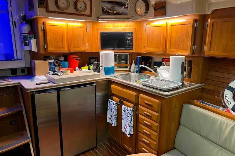 Slide: The Image of 1992 Luhrs 380 Open yacht kitchen with wooden cabinets, stainless steel appliances, and cozy lighting. - 47