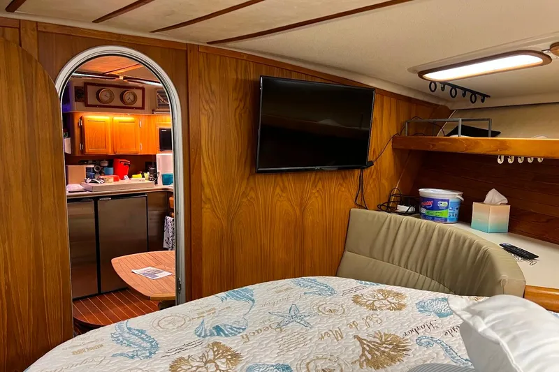 Slide: The Image of Interior of 1992 Luhrs 380 Open boat with wood paneling, TV, and cozy cabin space. - 49