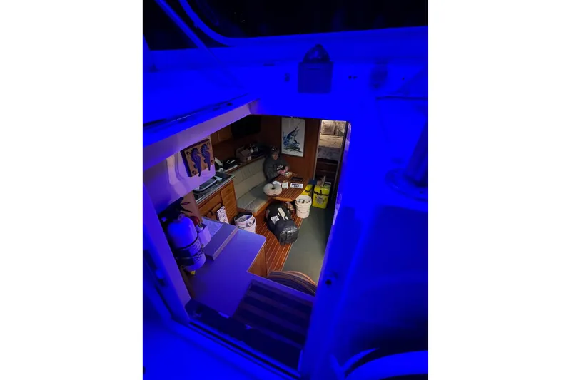 Slide: The Image of Interior view of 1992 Luhrs 380 Open boat, featuring cozy seating and ambient blue lighting. - 51