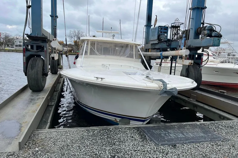 Slide: The Image of 1992 Luhrs 380 Open boat on lift at marina, overcast sky. - 60