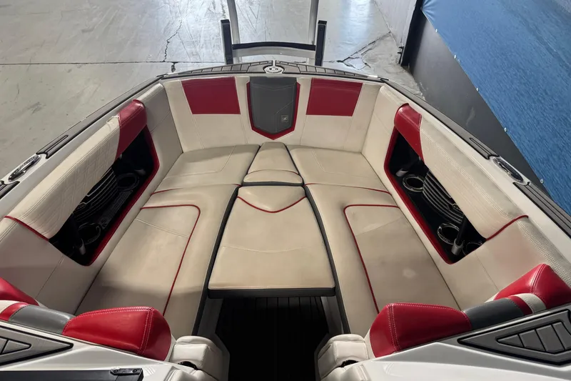 Slide: The Image of 2019 Nautique Super Air Nautique G23 boat interior with red and beige seating. - 12