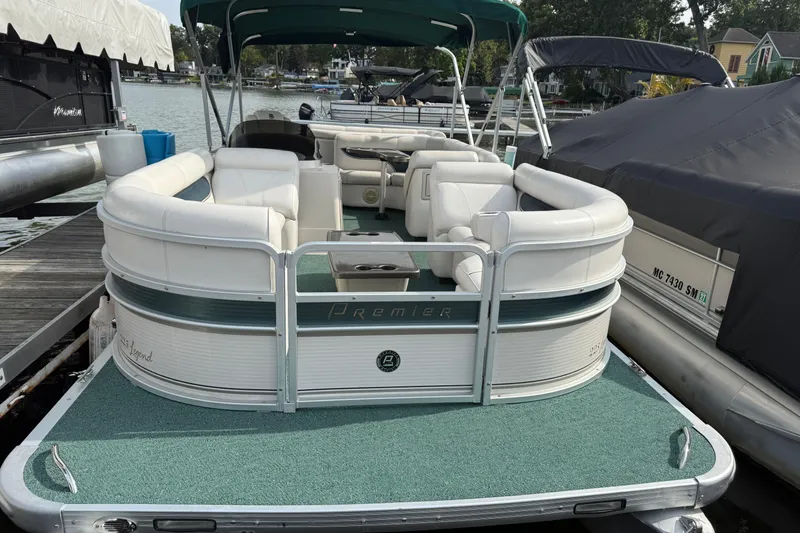 The Image of 2007 Premier 22 pontoon boat docked, featuring white seating and green carpet. - 0