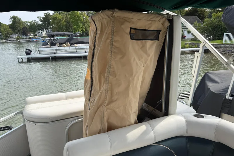 Slide: The Image of Pontoon boat interior with tan cover, Premier 22 model, 2007, docked by a lake. - 19