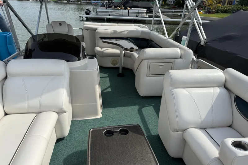 Slide: The Image of Luxurious 2007 Premier 22 pontoon boat interior with white seating and green carpet. - 22