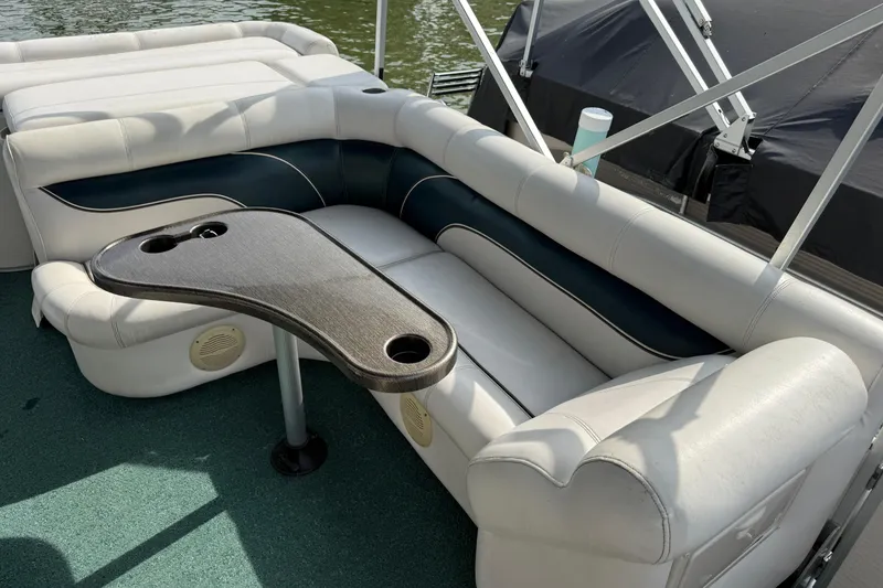 Slide: The Image of Premier 22 pontoon boat interior, 2007 model, featuring white seating and a table with cup holders. - 7