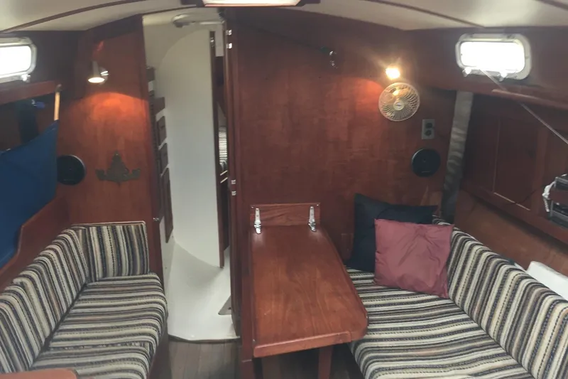 Slide: The Image of Interior of a 1982 Tartan 33 sailboat with striped seating and wooden finishes. - 3