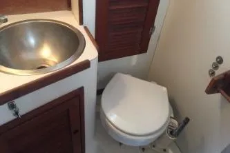 Slide: The Image of 1982 Tartan 33 yacht bathroom with sink and toilet, featuring wooden accents. - 5
