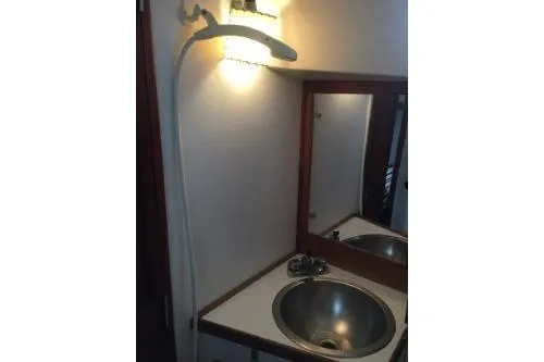 Slide: The Image of 1982 Tartan 33 yacht bathroom with sink, mirror, and wall light. - 6