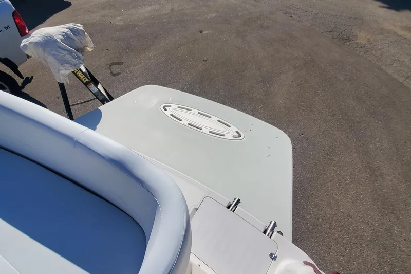 Slide: The Image of 1997 Chaparral Signature 240 boat with white seating and deck, parked on asphalt. - 11