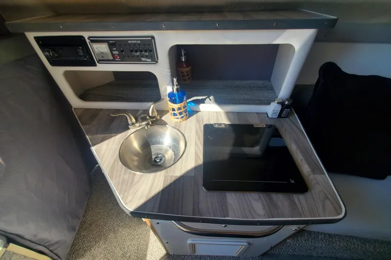 Slide: The Image of 1997 Chaparral Signature 240 boat interior with sink, stove, and control panel. - 13